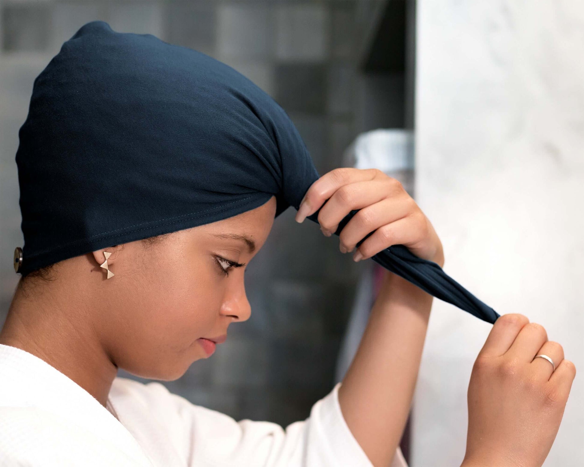 Woman using a T-Shirt Hair Towel Hood for Curly, Wavy, and Straight Hair - Soft, Absorbent and Eco-Friendly in Navy Blue