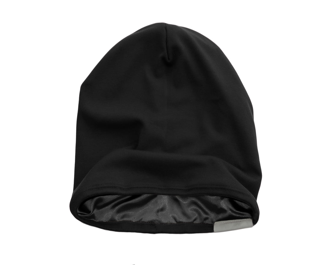 Satin lined beanie worn by a woman, showcasing its softness and warmth in black color.