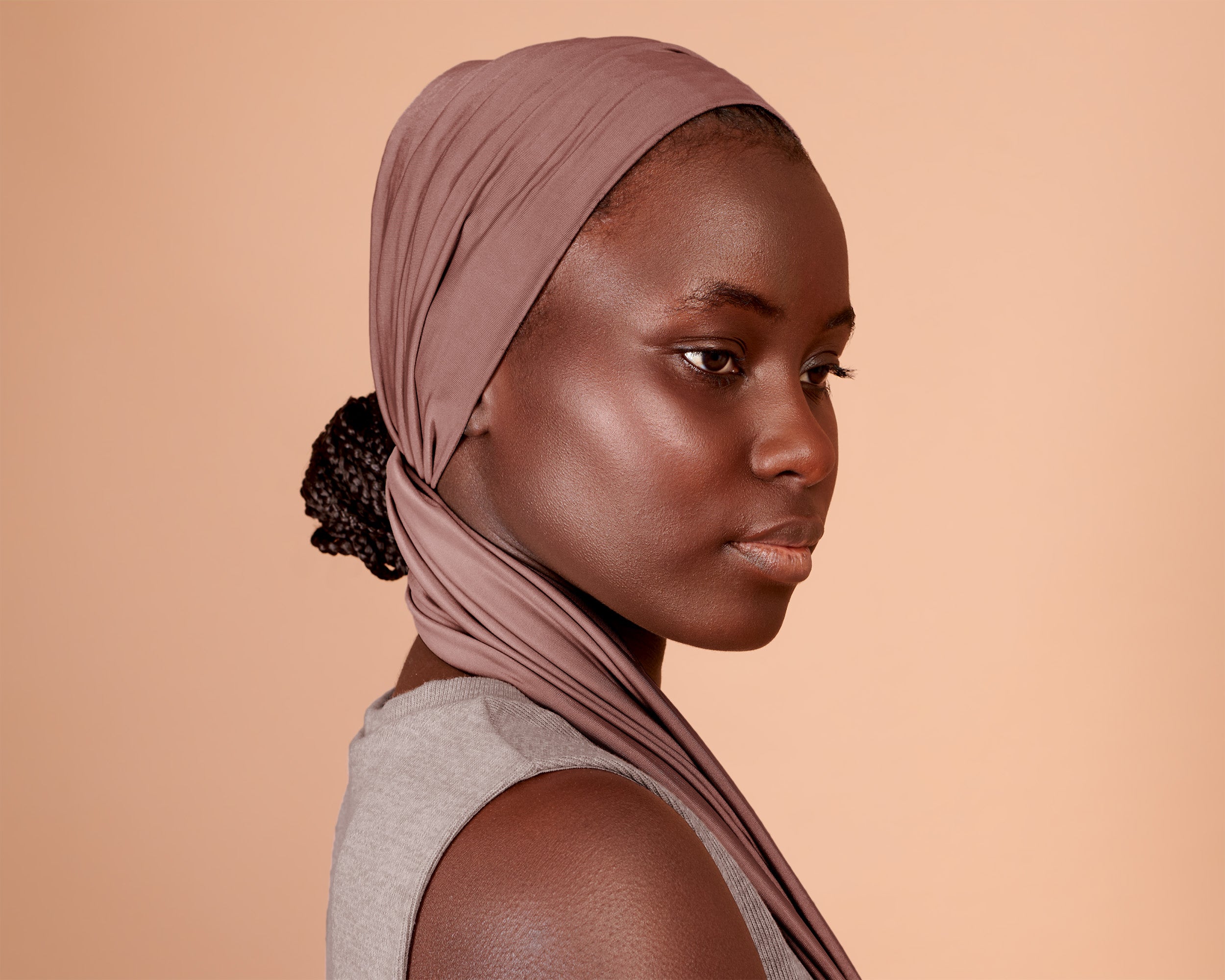 Woman wearing a Wide Boho Hair Wrap in mocha rose color, against a beige background