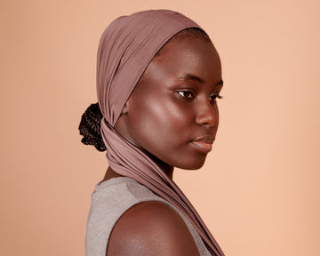 Woman wearing a Wide Boho Hair Wrap in mocha rose color, against a beige background