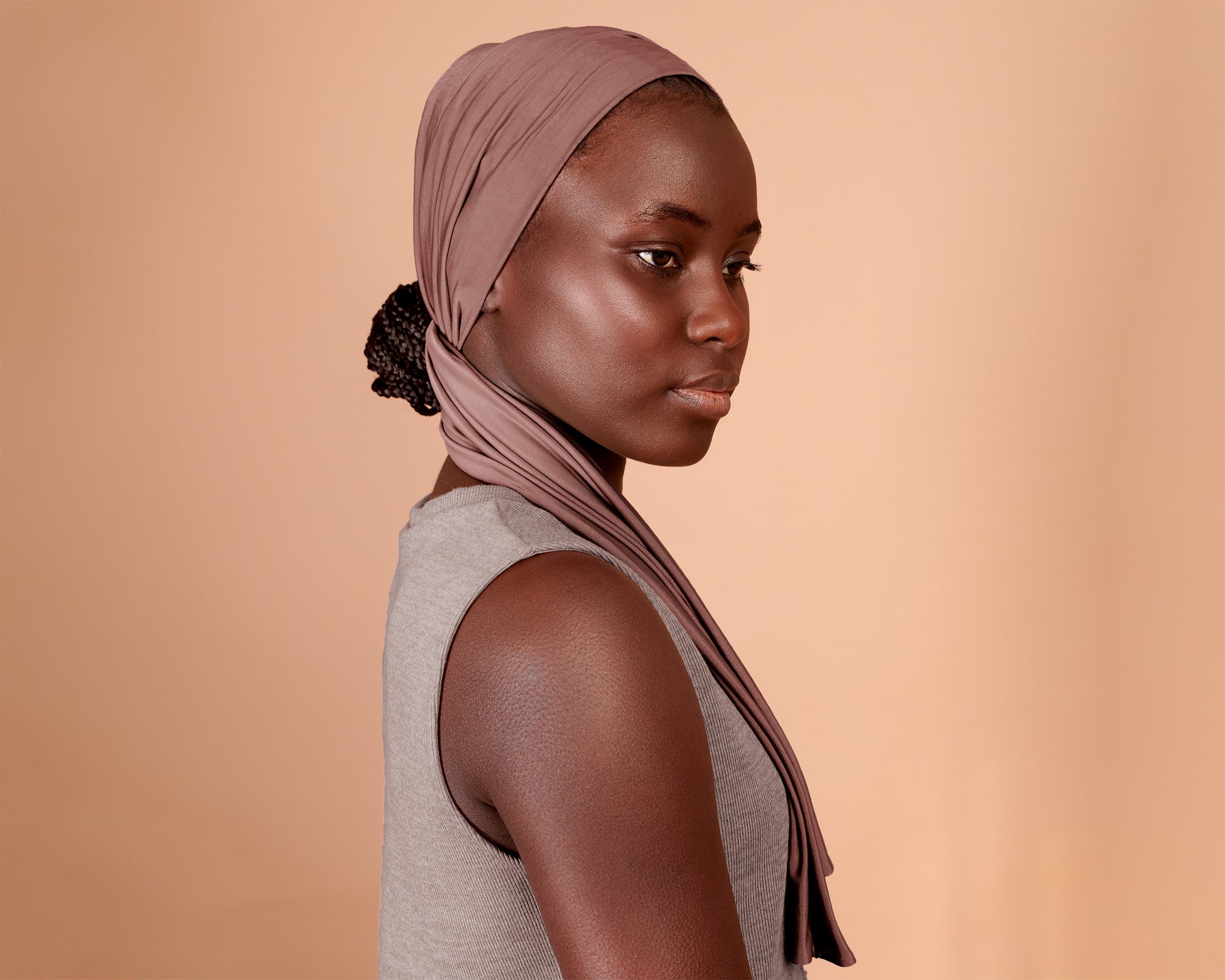 Woman wearing a Wide Boho Hair Wrap in mocha rose color, against a beige background