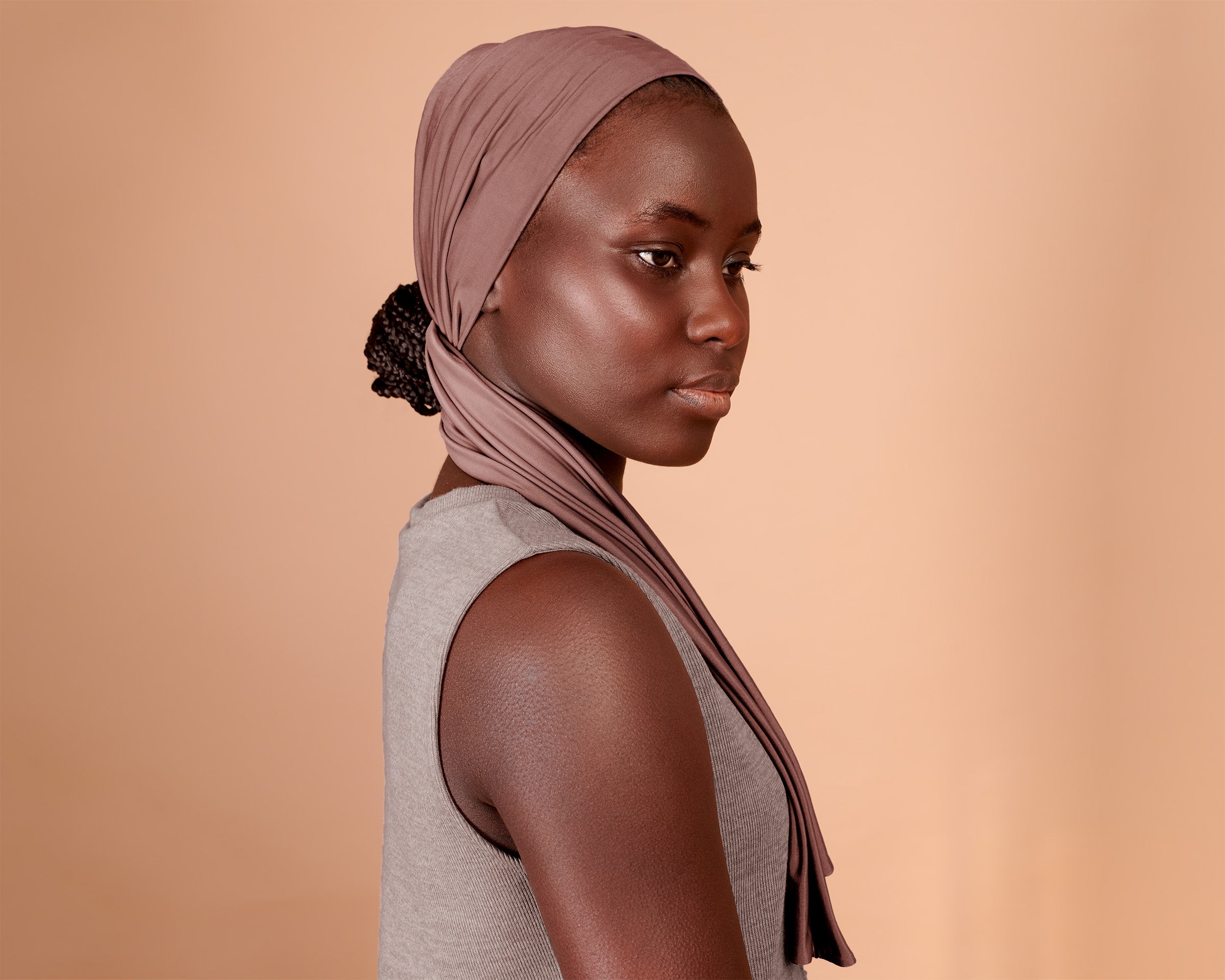 Woman wearing a Wide Boho Hair Wrap in mocha rose color, against a beige background