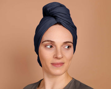 Woman using a T-Shirt Hair Towel for Curly, Wavy, and Straight Hair - Soft, Absorbent, and Eco-Friendly in Navy Blue