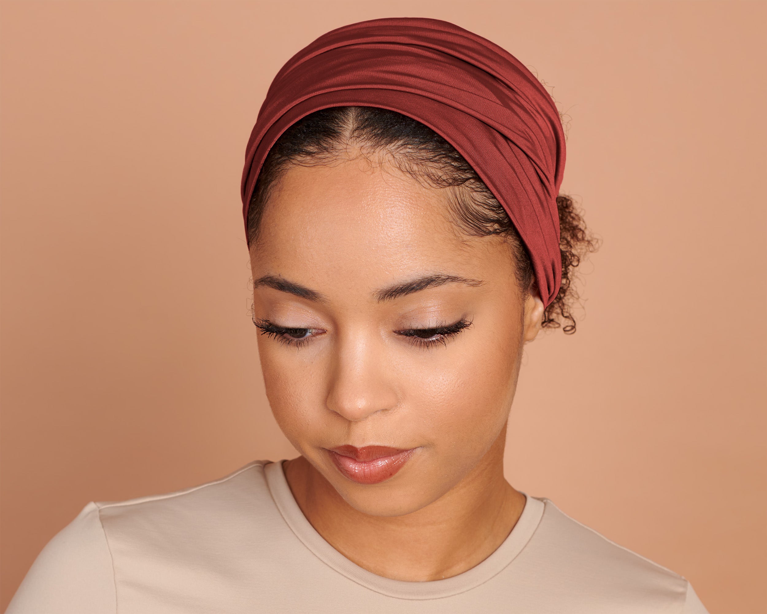 Woman wearing a Boho Headband Extra Wide in Rust Orange, against a beige background