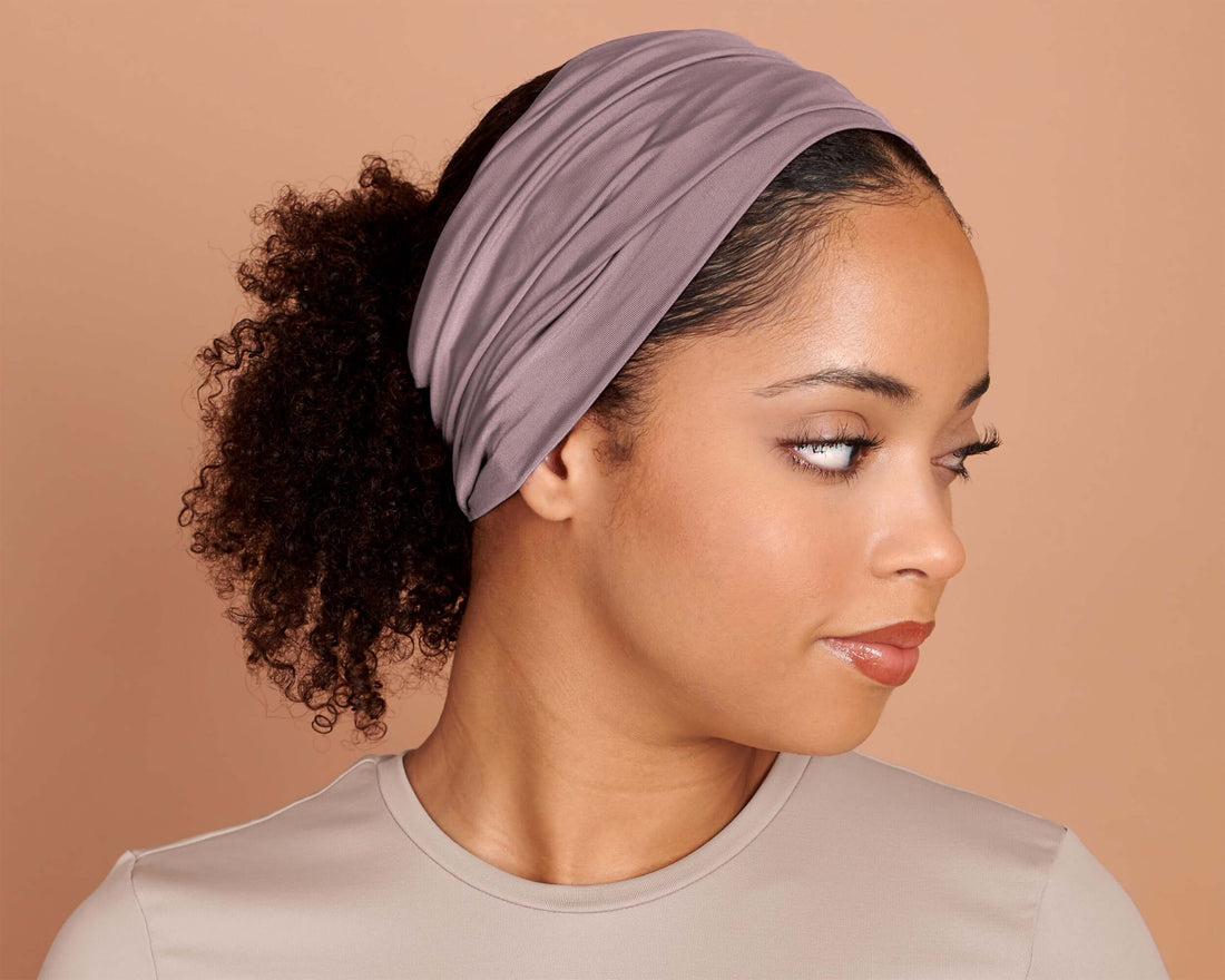 Woman wearing a mauve headband against a beige background