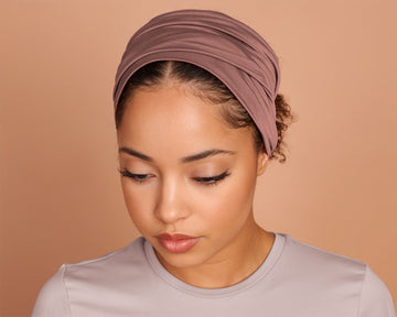 Woman wearing a Boho Headband Extra Wide in Mocha Rose color, against a beige background