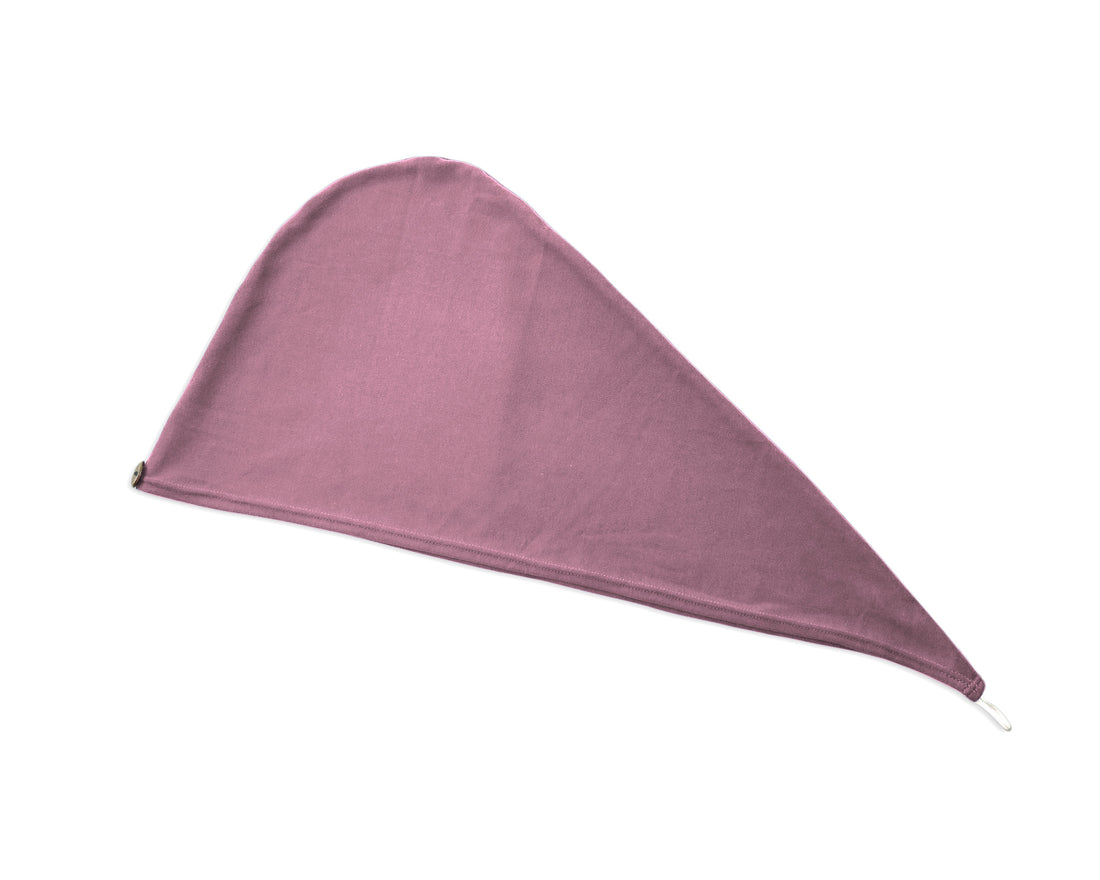Woman adjusting a T-Shirt Hair Towel Hood for Curly, Wavy, and Straight Hair - Soft, Absorbent, and Eco-Friendly in lilac rose, with a blurred background
