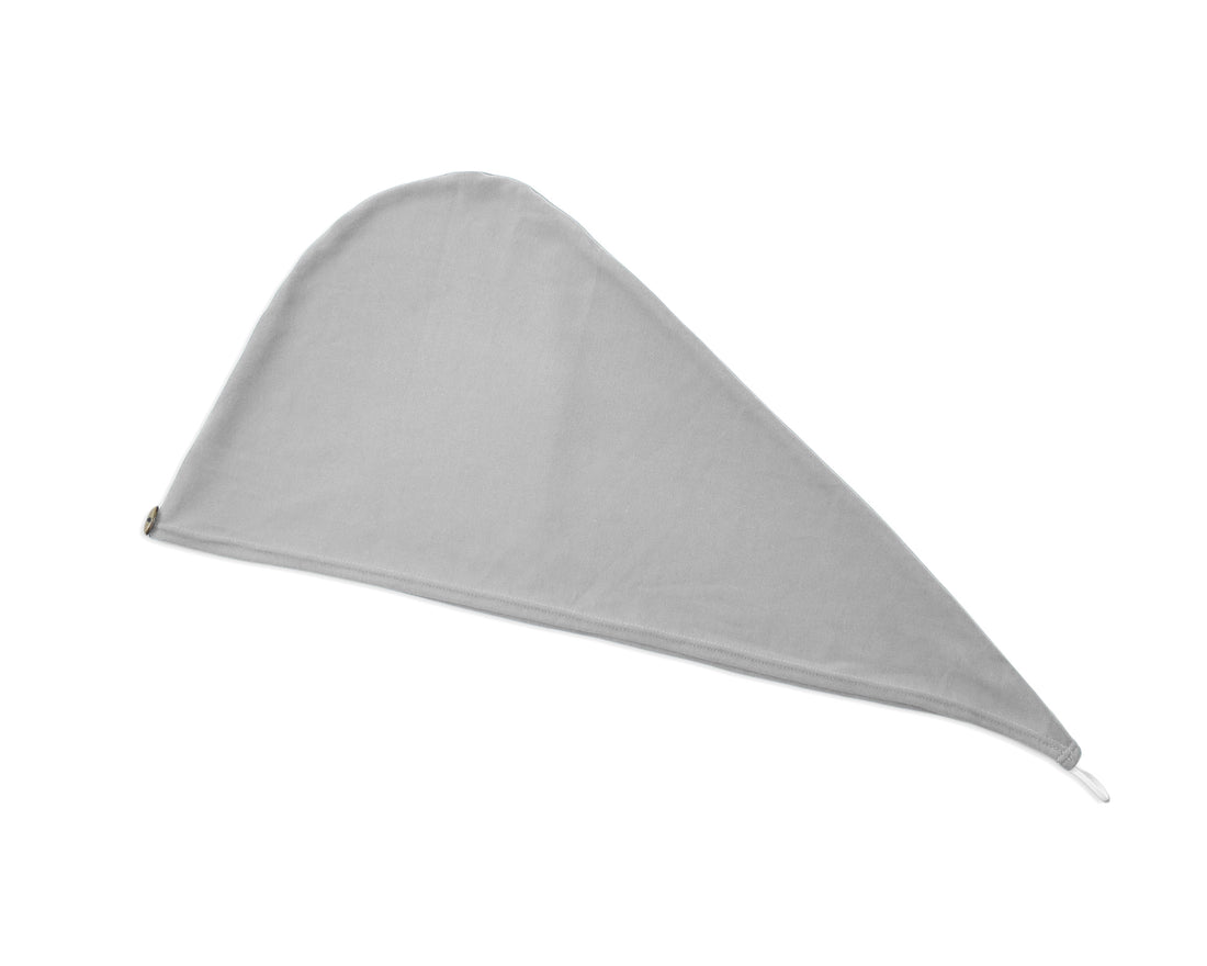 Woman adjusting a T-Shirt Hair Towel Hood for Curly, Wavy, and Straight Hair - Soft, Absorbent, and Eco-Friendly in gray, in a bathroom setting