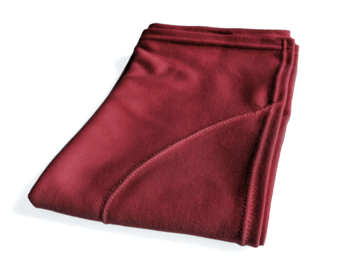 A woman  has wrapped the red burgundy t-shirt hair towel around their head, displaying the towel in use.