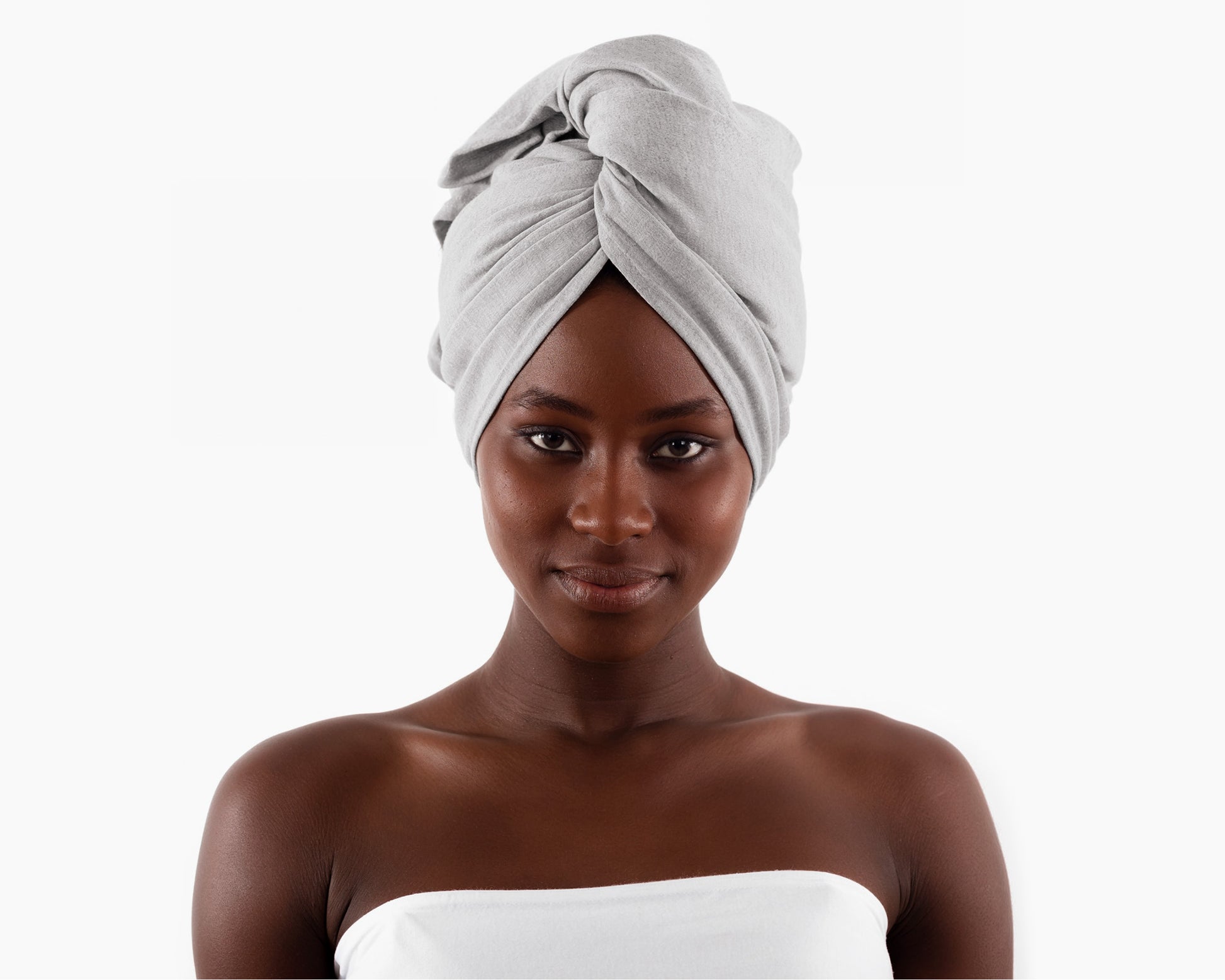 Woman wearing a gray T-Shirt Hair Towel for Curly, Wavy, and Straight Hair - Soft, Absorbent, and Eco-Friendly, wrapped around her head on a white background.