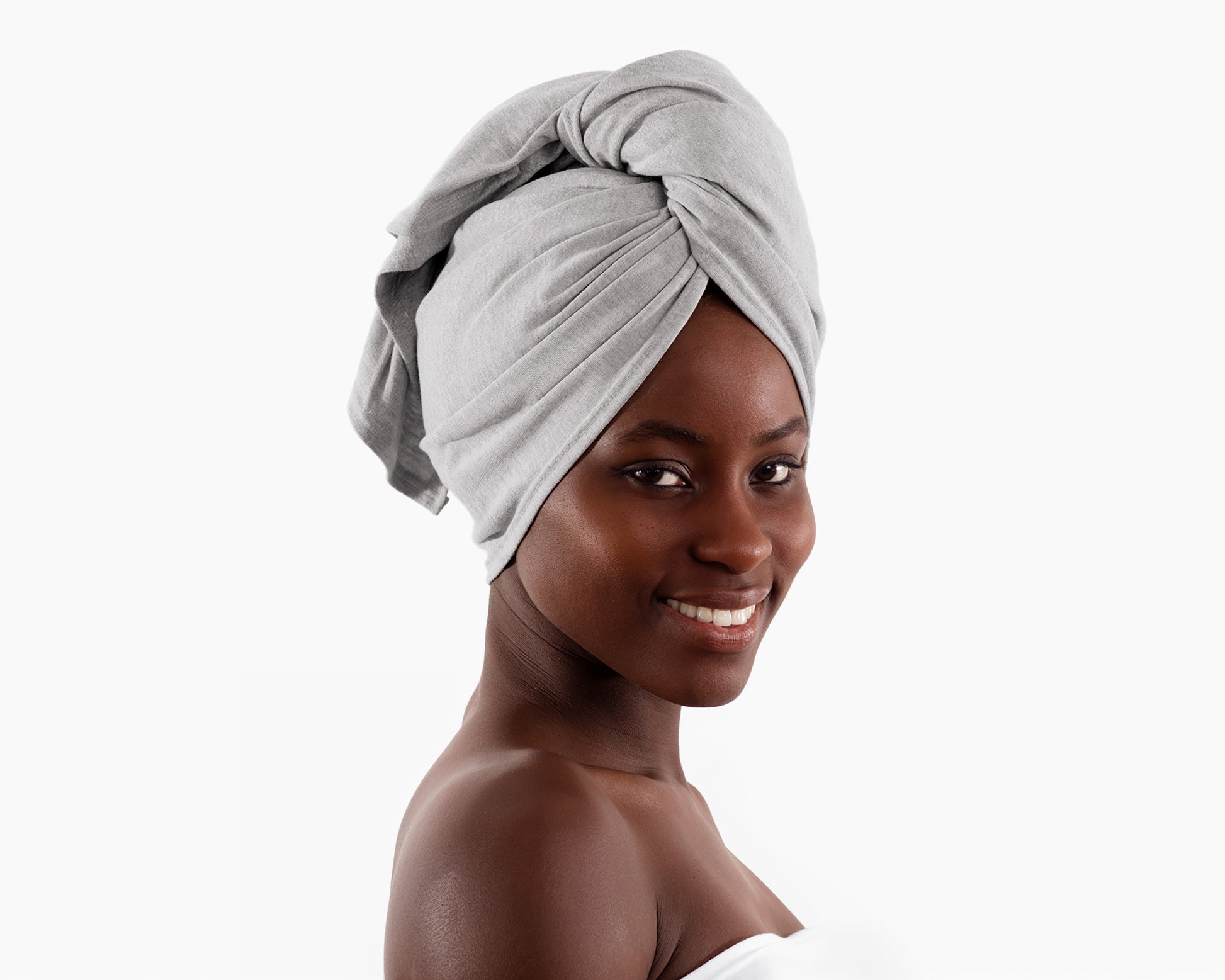 Woman wearing a gray T-Shirt Hair Towel for Curly, Wavy, and Straight Hair - Soft, Absorbent, and Eco-Friendly, wrapped around her head on a white background.