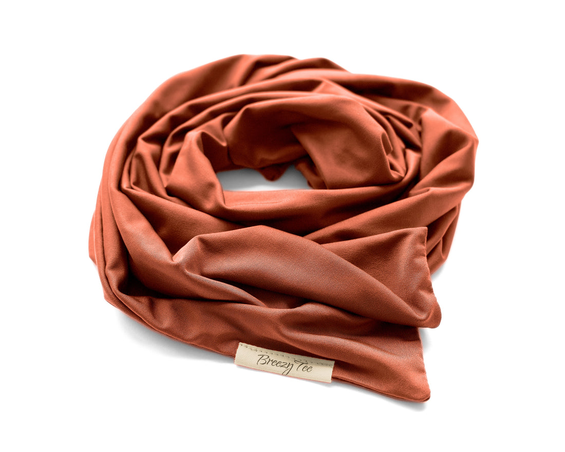 Woman wearing a rust-colored head wrap, against a beige background