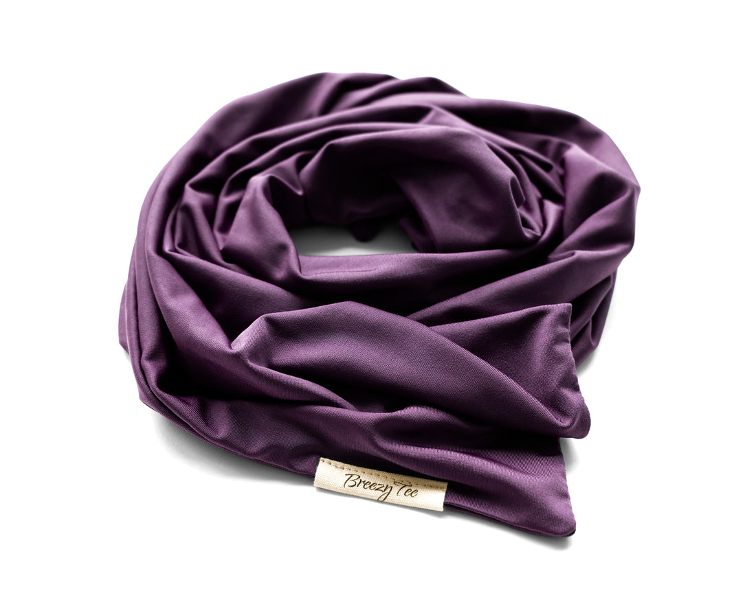 A woman wearing a Boho Head Wrap Wide Hair Wrap in light plum with her hair styled in a bun, shown in profile against a solid warm beige background.
